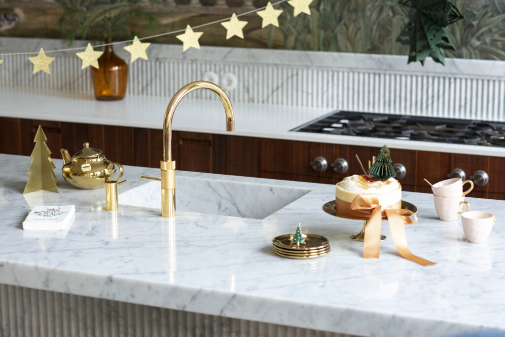 The main image of a gold Quooker tap which is decorated for Chrismtas.